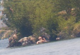 mulher depilando a buceta com pince na beira do rio